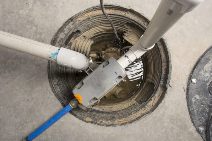 A newly installed sump pump in an uncovered sump pit as seen from above.