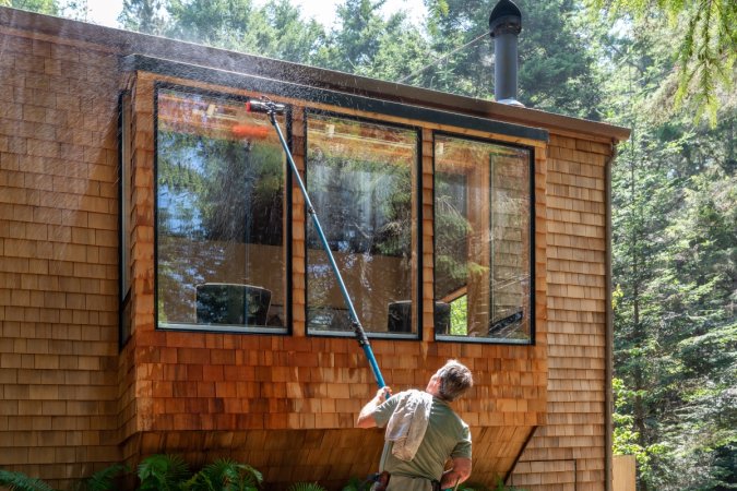 Mean using a long pole to clean the windows outside a house