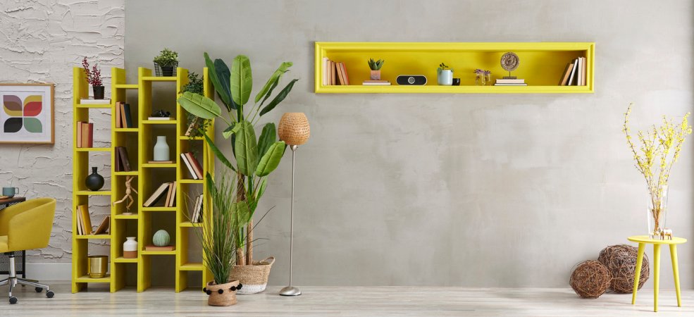 Grey stone wall, room, interior style with yellow niche, green vase of plant, bookshelf decor.