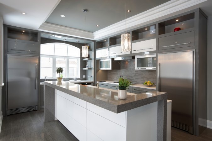 View of modern luxury kitchen with island and stainless steel appliances.