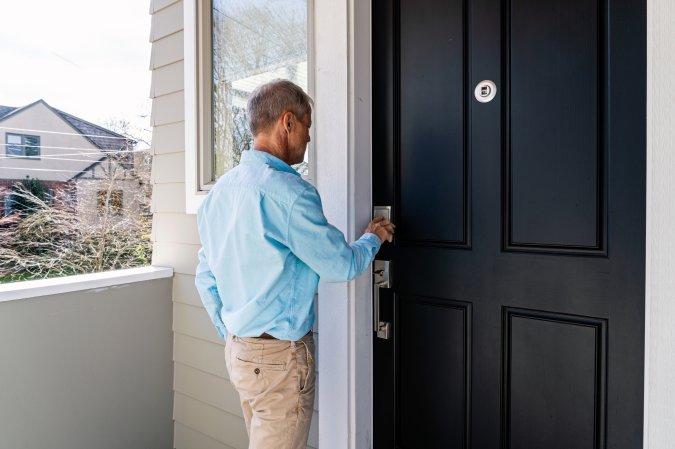A man unlocking his front door with a smart keypad.