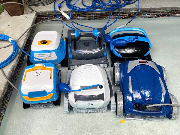 A group of the best robotic pool cleaner options together next to a pool